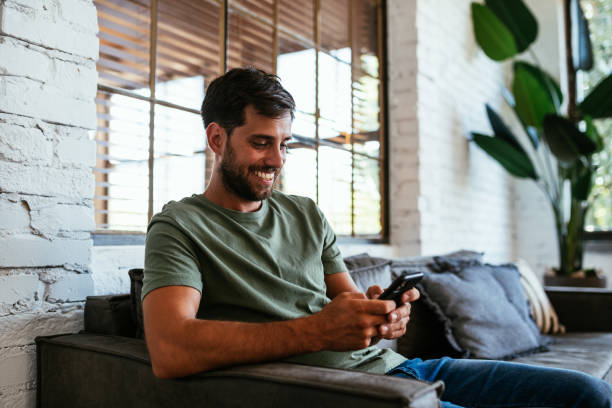 istock Cheerful Caucasian man working from home and using smart phone for online payments 1432483259
