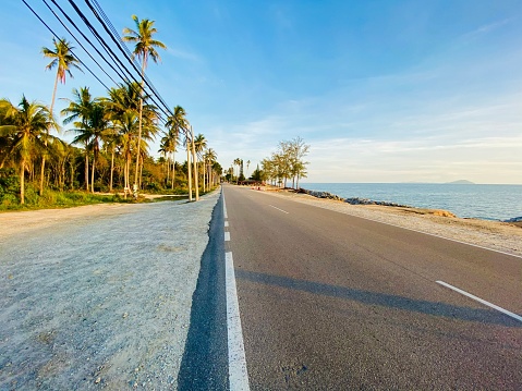 asphalt road and white sand beach at praslin island, seychelles islands, indian ocean islands.