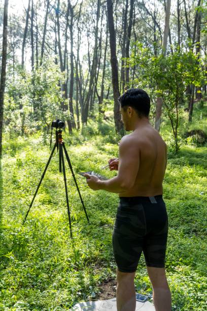 istock Young Hispanic athletic man video blogging in a forest before or after a workout 1432485305