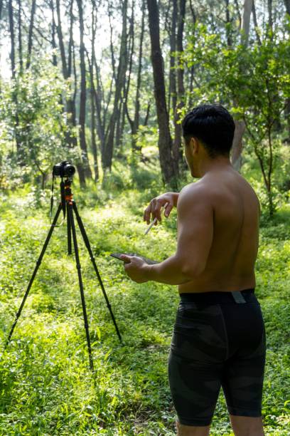 istock Young Hispanic athletic man video blogging in a forest before or after a workout 1432485306