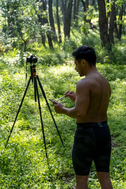 istock Young Hispanic athletic man video blogging in a forest before or after a workout 1432485314