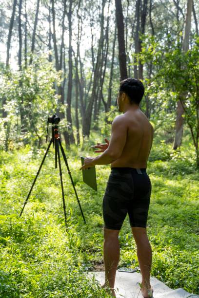 istock Young Hispanic athletic man video blogging in a forest before or after a workout 1432485320