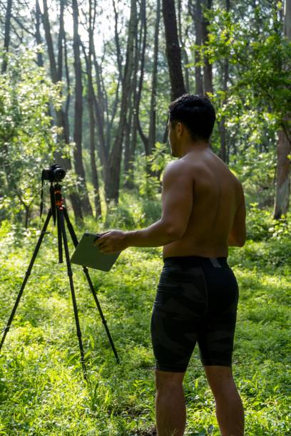 istock Young Hispanic athletic man video blogging in a forest before or after a workout 1432485321