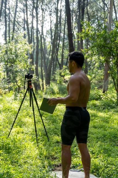 istock Young Hispanic athletic man video blogging in a forest before or after a workout 1432485324