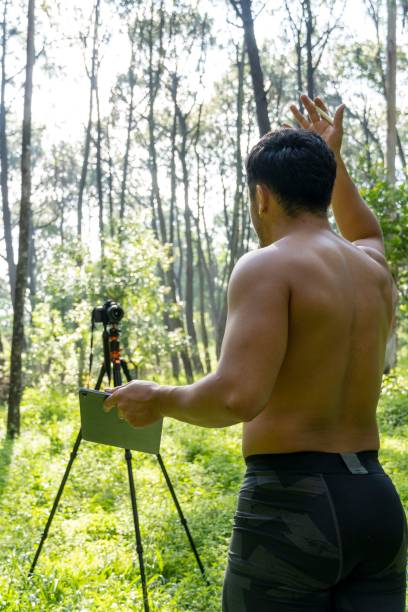 istock Young Hispanic athletic man video blogging in a forest before or after a workout 1432485325