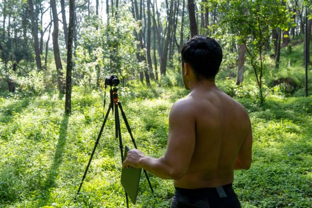 istock Young Hispanic athletic man video blogging in a forest before or after a workout 1432485335