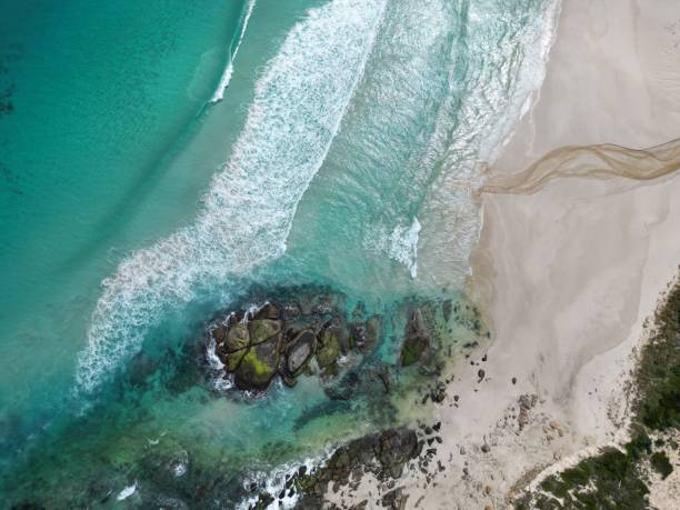 istock Top view of blue sea waves touching the sandy shore under the sunlight 1432486803