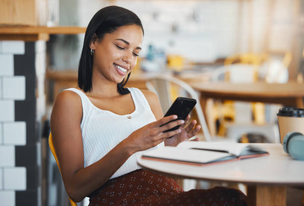 istock Texting a message or browsing social media on a phone by a young female student sitting in a coffee shop smiling. A relaxed woman relaxing and searching the internet or chatting online at a cafe 1432487425