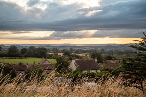 istock Cloudy sunset sky over a village in Cotswolds, UK 1432487486