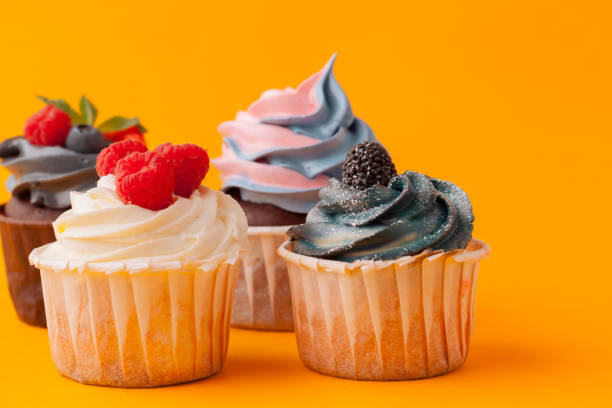 istock Delicious cupcakes with icing on a yellow background 1432487664