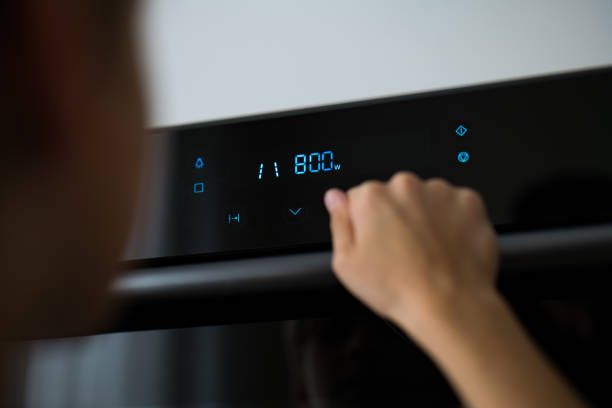 istock Detail of a child's hand while using a microwave. touch display microwave oven 1432487791