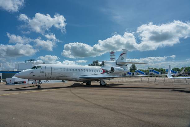 огромный и недавно разработанный большой dassault falcon 8x business jet на земле под голубым небом - falcon стоковые фото и изображения