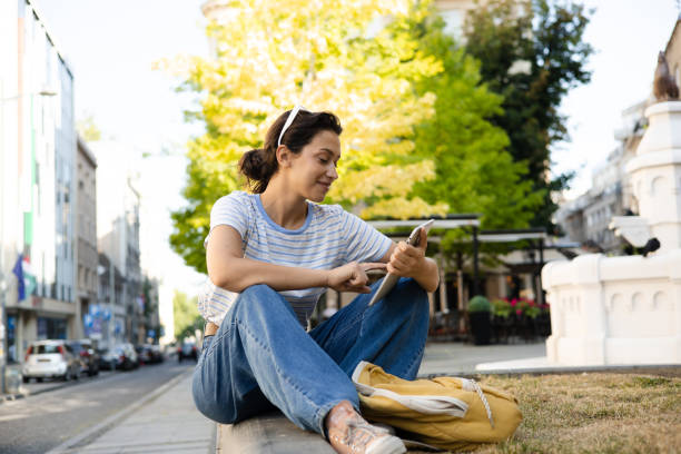 istock Portrait of a happy student taking a break on the street and using tablet 1432489169