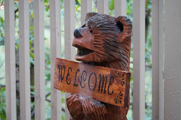 istock Wooden bear sculpture holding a welcome sign 1432490569