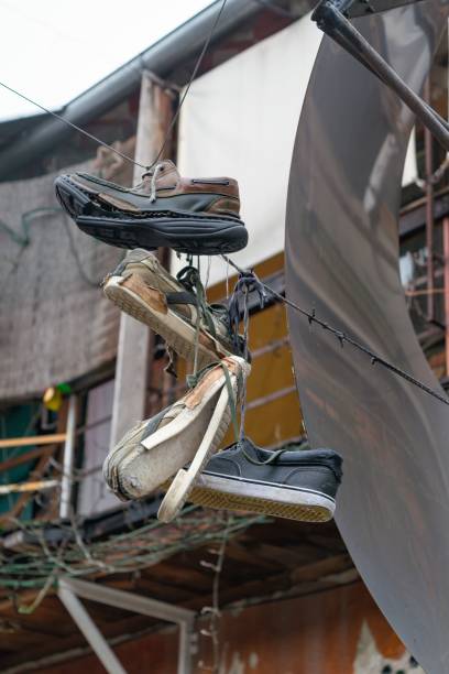 istock Vertical shot of old shoes hanging on a wire 1432491990