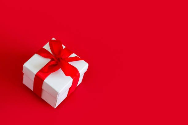 istock White box with a red ribbon on a red background, copy space. Greeting card concept. Christmas gift 1432492097
