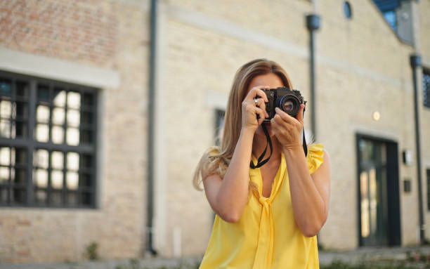 istock Beautiful woman taking pictures with her camera while exploring a city 1432494572