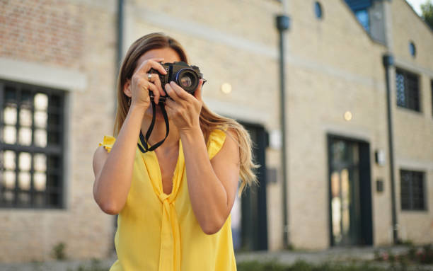 istock Beautiful woman taking pictures with her camera while exploring a city 1432494621