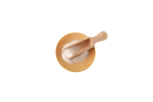 Msg. Food additive E621 in wooden scoop isolated on white background, top view. Glutamic acid monosodium. Flavor seasoning for enhancing food impressions. The additive is used in the food industry.