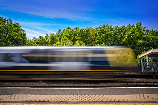 Train passing through a UK station at high speed captured as motion blur