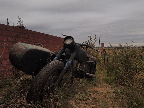 An old rusty motorcycle in field
