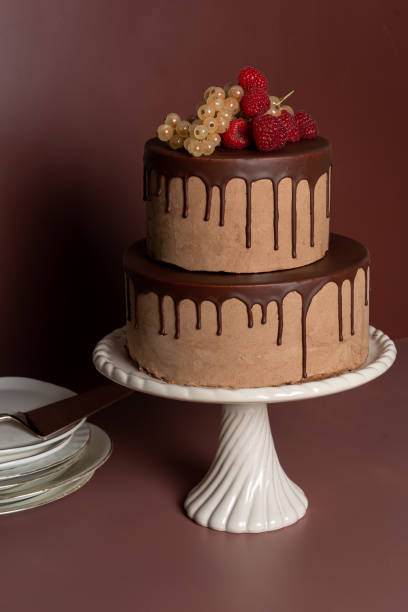 istock Celebration cake with fruit and plates on brown toned background 1432498041