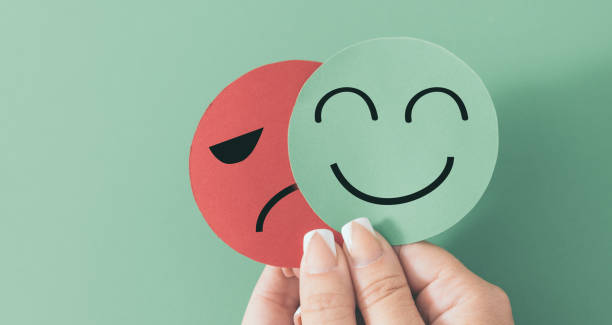istock Hand holds smiley face and sad or angry face, customer service rating, positive customer feedback, 1432499708