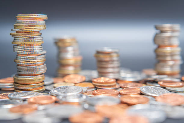 istock Stack of coins and heap coins on black table. 1432502842