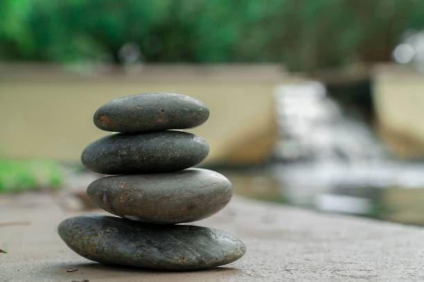 istock Closeup of a stack of stones with a waterfall in the background 1432503003