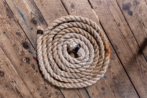 A top view of a twisted spiral rope on a wooden surface