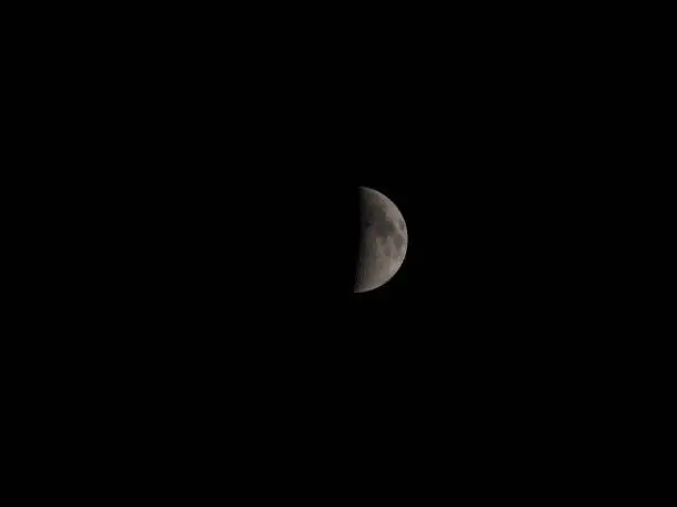 A closeup of the half moon shining in a dark night sky