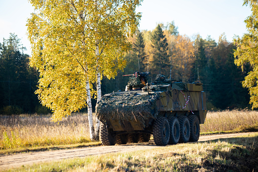 Military training on the battlefield with armored vehicles drives on forest road. Army war concept.