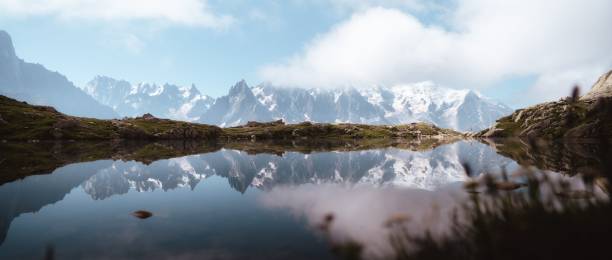 istock Panoramic view of snowy mountain range reflecting on a lake 1432507954