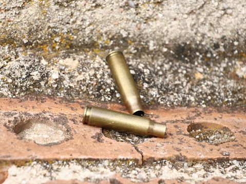 Bullet casings fired during a firefight. Street shooting. High school shooting. Shooting murder. War ammunition. Weapon. Shoot. Shot. Shot. War. Terrorism