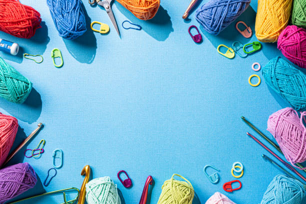 istock Crochet background with assorted colorful yarn and knit accessories over blue, top view, flat lay with copy space 1432514418