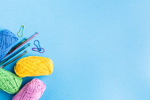 istock Crochet background with assorted colorful yarn and knit accessories over blue, top view, flat lay with copy space 1432514428