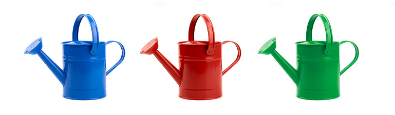 Watering can in three color. It is isolated on a white background