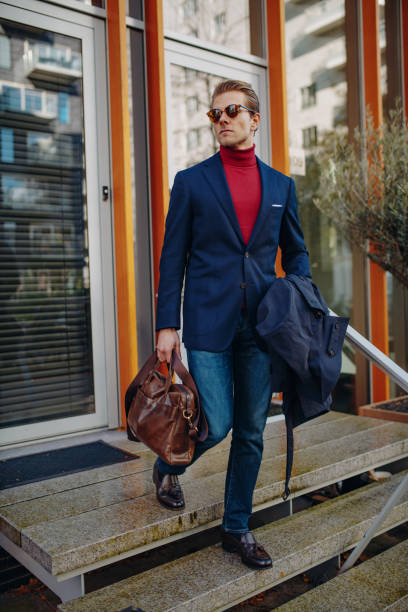 istock Young businessman going to work with leather bag and blue suit 1432520547