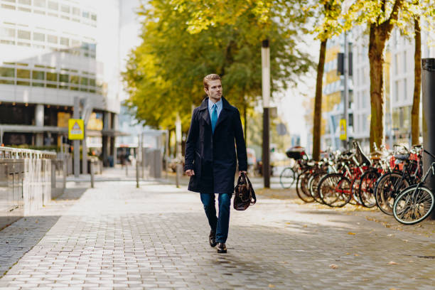 istock Young businessman going to work with leather bag and blue suit 1432520653