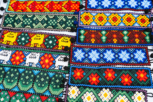 Huichol bracelets design variety at night market in Guadalajara, Mexico. Traditional Mexican handcraft souvenirs