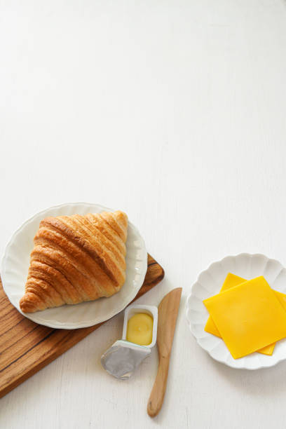 croissant with varius ingredient on white wood background.