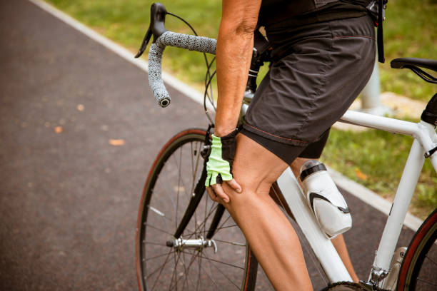 schmerzen im knie beim radfahren im freien - cyclist cycling road women stock-fotos und bilder