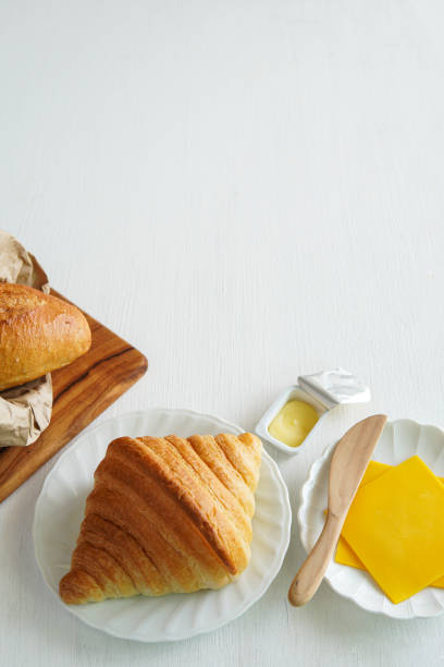 croissant with varius ingredient on white wood background.