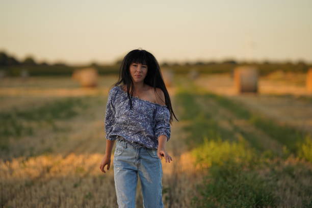 istock A girl with developing hair and a bare shoulder walks through a beveled field 1432523356