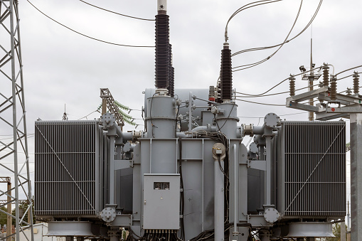 Modern powerful transformer substation with many connected high-voltage wires and cables, electrical equipment maintains a stable energy voltage