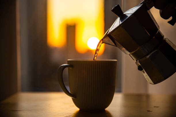 Pouring coffee into cup in the morning
