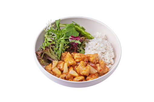 Meat in sauce with pineapple, rice, arugula, endive, salad, parsley in a plate on a white plate
