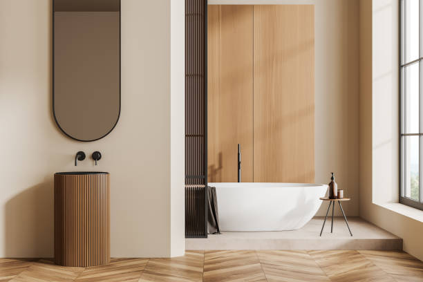 istock Light bathroom interior with sink and tub near panoramic window 1432538959