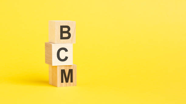 istock BCM - text on wooden cubes, on yellow background 1432541530