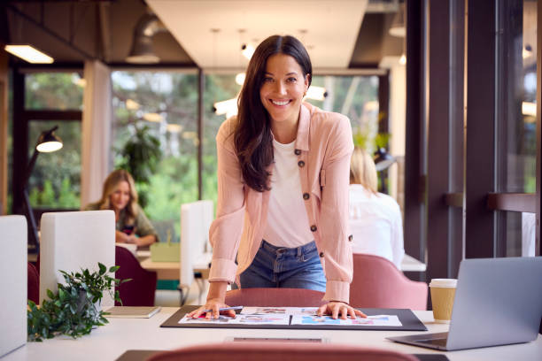 Retrato de empresária na mesa no escritório aprovando ou verificando provas ou layouts de design - foto de acervo